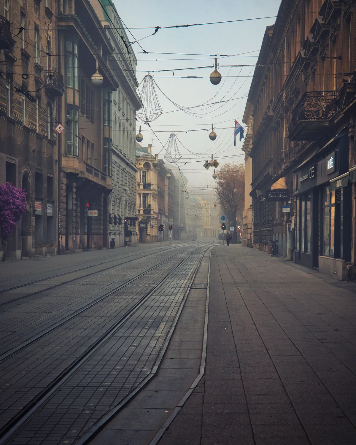 Prazna zagrebačka ulica s tramvajskim tračnicama u maglovito jutro